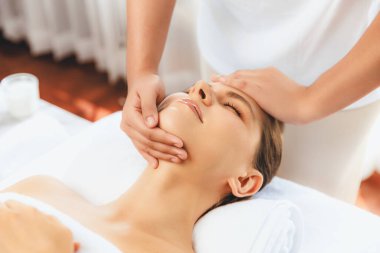 Kafkasyalı kadın stres önleyici kafa masajından ve lüks tatil beldesi ya da otel spa salonundaki modern ışık ortamında yüz güzelliği eğlencelerini şımartmaktan hoşlanıyor. Sessiz.