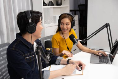 Gülümseyen radyo etkili sunucular, kulaklık takarak sosyal medya kanalından canlı yayın yapıyorlar ve sabah saatlerinde stüdyo kaydında dinleyicilere konu ve dizüstü bilgisayar üzerinden konuşuyorlar. İnfobahn.