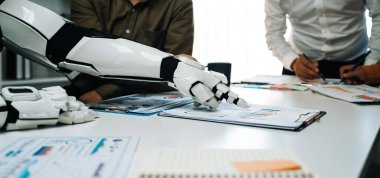 İş toplantısına katılan bir robot kol, modern çalışma ortamlarında veri analizi ve işbirliğini vurgulayarak teknolojinin ve insanların sinerjisini ön plana çıkarır.