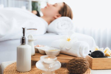 Aromaterapi masajı gündüz atmosferinde ya da spa salonunda bulanık bir kadına odak dekor ve spa aksesuarları kurarak tatil köyünde ya da otel arka planında keyifli aroma spa masajı yapan bir masaj. Sessiz.