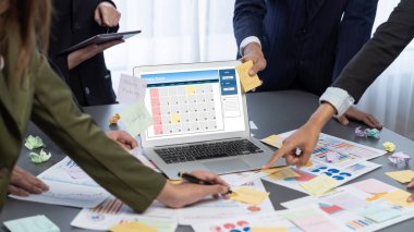 Analizci ekibi yaratıcı ve analitik beyin fırtınası fikri için bilgisayar ekranında BI veri paneli olan yapışkan bir not kullanıyor. Pazarlama stratejisi için finansal veri görselleştirme teknolojisini analiz et. Dahi.