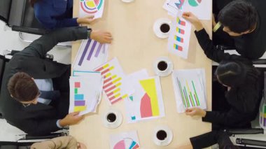 İş adamları grup toplantısı ofiste yukarıdan çekildi. İş kadınları, iş adamları ve ofis çalışanları, proje planlama belgeleriyle takım konferansında toplantı masasında çalışıyorlar. .