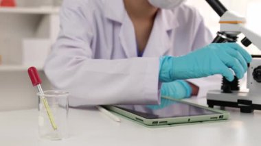 Laboratuvar kimya araştırmacısı mikroskop kullanarak yeni ilaç ya da tedavi geliştirir. Laboratuvar mikrobiyoloji ekipmanları ile bilimsel uzmanlık ile sağlık hizmetlerinin teknolojik gelişimi. Ağır çekim. Katı.