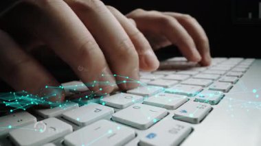 Close-up of hands typing on a laptop keyboard with floating graphics representing data analytics and modern technology, showcasing productivity and innovation. Xenic