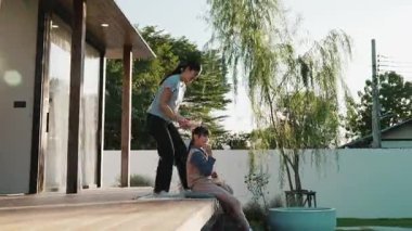 Şirin baba, anne ve kızı birlikte evin bahçesinde oturuyorlar. Ebeveynler, çevre farkındalığıyla ilgili genç nesli iletişim kurmak için açık hava aktivitelerini kullanırlar. Uyumsuzluk.