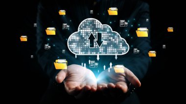 Elleri parlak bir ışık tutan bulut deposunun dijital bir temsili. Semboller dosya yükleme ve indirme, teknoloji ve iş yeniliklerini gösteriyor. Dörtgen