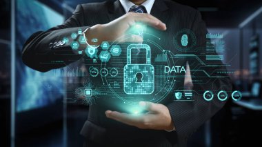 Bir işadamı, verileri holografik grafiklerle modern bir ofiste koruyarak dijital güvenlik kavramlarını görselleştiriyor ve veri korumanın önemini gösteriyor. Dörtgen