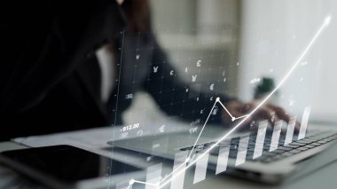 A modern workspace showcasing a laptop with digital financial graphs, reflecting growth trends and data analysis. Perfect for business and finance themes. Copula