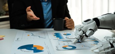 Bir insan ve robotik kol bir iş toplantısına katılır, masadaki veri tablolarını analiz eder, teknoloji ve insan zekası arasındaki işbirliğini etkili kararlar vermek için gösterir. Noogenesis