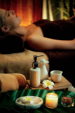Aromaterapi masajı ambiyansı ya da spa salonu kompozisyon düzeneği bulanık kadınlara odaklı dekor mumları ve spa aksesuarları ile tatil köyü veya otel arka planında keyifli aroma spa masajı yapan. Sessiz.