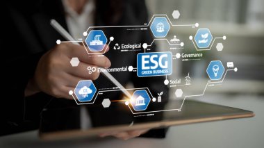 A business professional using a tablet to explore an ESG digital interface, emphasizing sustainable practices in management, governance, and environmental responsibility. Tessel
