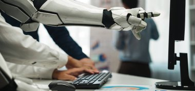 Modern bir ofiste bir robot kol, günümüzün dinamik çalışma yerinde insan yaratıcılığı ve ileri teknolojinin karışımını vurgulayan bir bilgisayarla bağlantı kurar.