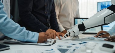 Bir ofis ortamında bir insan takımı, iş analizi ve devam eden ve gelecekteki projeler için yenilikçi çözümlere odaklanan bir robot kol ile işbirliği yapıyor. Noogenesis