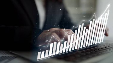 A business professional is engaged in data analysis using a laptop, showcasing a modern graph with an upward trend, highlighting financial success and strategic planning. Copula
