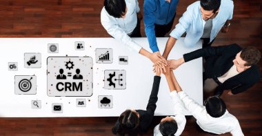 A diverse team collaborates on a CRM strategy in a modern office, showcasing unity and focus on performance-enhancing goals. Engagement and innovation are key. Trope