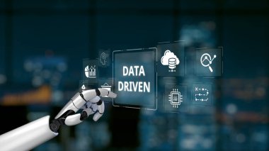 A robotic hand interacts with digital icons representing data and analytics in a futuristic smart office. The modern setting features a city skyline at night, emphasizing innovation. Synapse