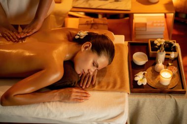 Beyaz kadın müşteri stres önleyici spa masajının keyfini çıkarıyor ve lüks otel ya da otelde sıcak mum ışığında güzellik teniyle eğleniyor. Sessiz.