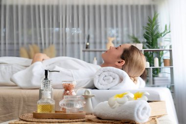Aromaterapi masajı gündüz atmosferinde ya da spa salonunda bulanık bir kadına odak dekor ve spa aksesuarları kurarak tatil köyünde ya da otel arka planında keyifli aroma spa masajı yapan bir masaj. Sessiz.