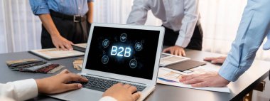 İş adamı B2B peyzajında geziniyor, iş-iş bağlantılarını geliştirmek için kullanım teknolojisi kullanıyor. B2B etkileşimini yeniden şekillendiren keşifler, iş-iş stratejilerinde yenilikleri yönlendiren araçlar. canlı