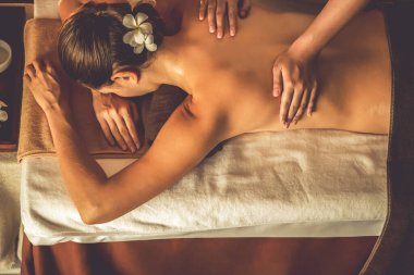 Beyaz kadın müşteri stres önleyici spa masajının keyfini çıkarıyor ve lüks otel ya da otelde sıcak mum ışığında güzellik teniyle eğleniyor. Sessiz.