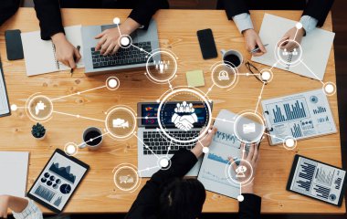 Engaging business meeting scene highlighting teamwork and technology, featuring laptops, data charts, and collaborative discussions in a modern workspace setting. Amity
