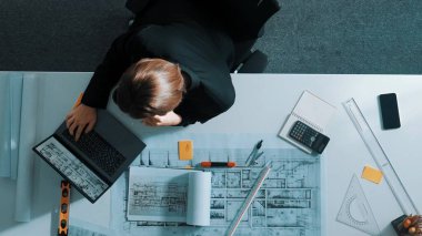 İnşaat mühendisinin elinde kahve tutarken ve toplantı odasında dururken telefonla müdürle konuşması zaman aşımı. Hava görüntüsü mimarı arıyor ve bina yapısından bahsediyor. Hizalama.