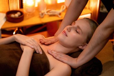 Beyaz kadın müşteri stres önleyici spa masajının keyfini çıkarıyor ve lüks otel ya da otelde sıcak mum ışığında güzellik teniyle eğleniyor. Sessiz.