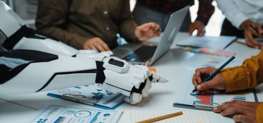 Modern ofis ortamında insanlarla bir robot arasındaki etkileşimi gösteren dinamik bir buluşma sahnesi. Veri analizi ve yenilikçi fikirler vurgulanmıştır.