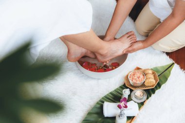 Adam lüks kaplıcalarda mutlu ayak masajına devam ederken, masör de hafif gün ışığı atmosferinde refleksoloji terapisi ya da otel ayak spa 'sında. Sessiz.