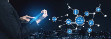 A business professional engages with a tablet surrounded by a digital network visualization, illustrating technology, connections, and city skyline at night. Tessel