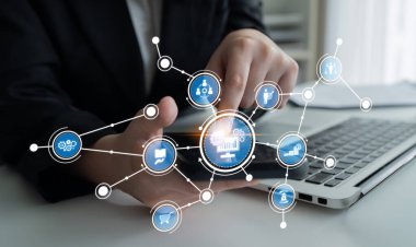 A business professional interacts with a laptop in a modern office, managing data analytics represented by digital icons, showcasing modern business technology and connectivity. Crux