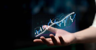 A hand displays a digital financial chart showcasing colorful bars and glowing arrows pointing upward, representing growth, investment, and success in business. Impute