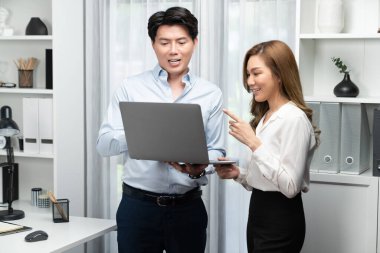 Gülümseyen Asyalı iş arkadaşları modern ofiste dizüstü bilgisayar pazarlama projesi hakkında konuşurken. Yeni sosyal medya kanalında başarılı müşteri ihtiyaçları analiz ediliyor. İnfobahn.