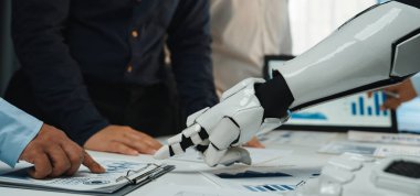 Robot bir elin insan elini sıktığını gösteren, takım çalışması ve teknoloji entegrasyonunu gösteren modern bir iş toplantısı. Belgeler ve çizelgeler mevcut, veri analizleri vurgulanıyor. Noogenesis