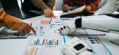 Modern ofis ortamında insan ve robot arasındaki veri tabloları ve büyüme ölçümlerini analiz eden canlı bir iş görüşmesi. Noogenesis