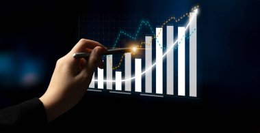 A hand points at a financial chart showing an upward trend. The image represents business growth, analysis, and financial success in a corporate environment. Impute