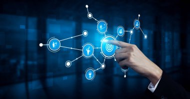 A hand interacts with a digital touchscreen, engaging with a network of icons in a blue background, symbolizing modern technology and digital connection. Tessel