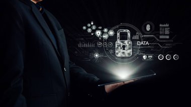 Bir iş adamı elinde yüzen dijital bir kilitle fütüristik grafikler arasında veri güvenliğini sembolize ederek siber güvenliğin önemini vurgulayan bir tabletle ayakta duruyor. Dörtgen