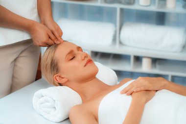 Kafkasyalı kadın stres önleyici kafa masajından ve lüks tatil beldesi ya da otel spa salonundaki modern ışık ortamında yüz güzelliği eğlencelerini şımartmaktan hoşlanıyor. Sessiz.