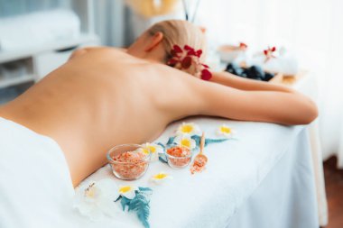 Lüks spa salonlarında sıcak mum ışığında cilt bakımı yaptıran kadın müşteri. Sağlık Spa vücut fırçasında tuz temizleme güzellik tedavisi. Sessiz.