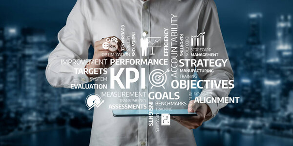 A businessman analyzes key performance indicators using a digital tablet in a modern office environment, focusing on goals, strategy, and performance management essentials. Tessel