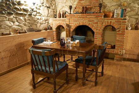 Téléchargez les photos : Une table près de la cheminée dans un confortable café géorgien. Kutaisi, Géorgie - 04.06.2021 - en image libre de droit