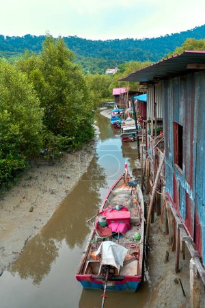 Photo for Fishermen's village in Asia. Boats near dilapidated houses on stilts. - Royalty Free Image