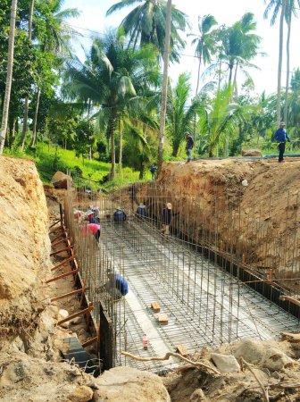 Téléchargez les photos : Construction dans la forêt de jungle. Les travailleurs versent du béton dans la fondation. Samui, Thaïlande - 02.26.2020 - en image libre de droit