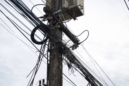 Foto de A wooden power line pole in Thailand. A huge number of wires. - Imagen libre de derechos