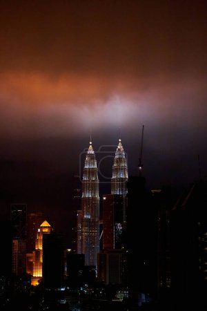 Photo for The night landscape of downtown Kuala Lumpur. View of the famous petronas oil company towers. The lighting of the buildings illuminates the clouds. Kuala Lumpur, Malaysia - 06.05.2020 - Royalty Free Image