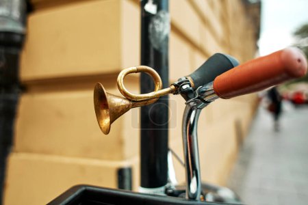 Close-up of a brass retro horn on a bicycle handlebar