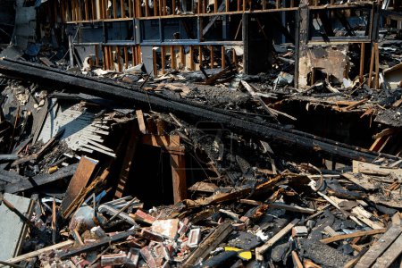 Ein ausgebranntes altes Holzhaus nach einem Brand. Verkohlte Balken nach der Zerstörung