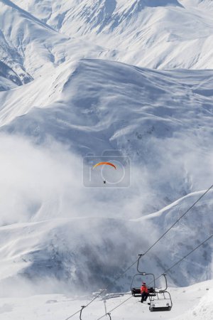 Foto de Telesilla y paraplano en la niebla en la estación de esquí en el frío día de invierno. Montañas nevadas del Cáucaso. Georgia, región Gudauri. - Imagen libre de derechos