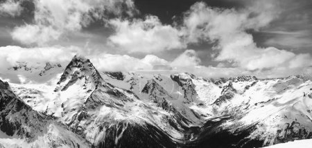 Photo for Black and white panorama of snowy winter mountain in sunlight clouds. Caucasus Mountains, region Dombay. - Royalty Free Image
